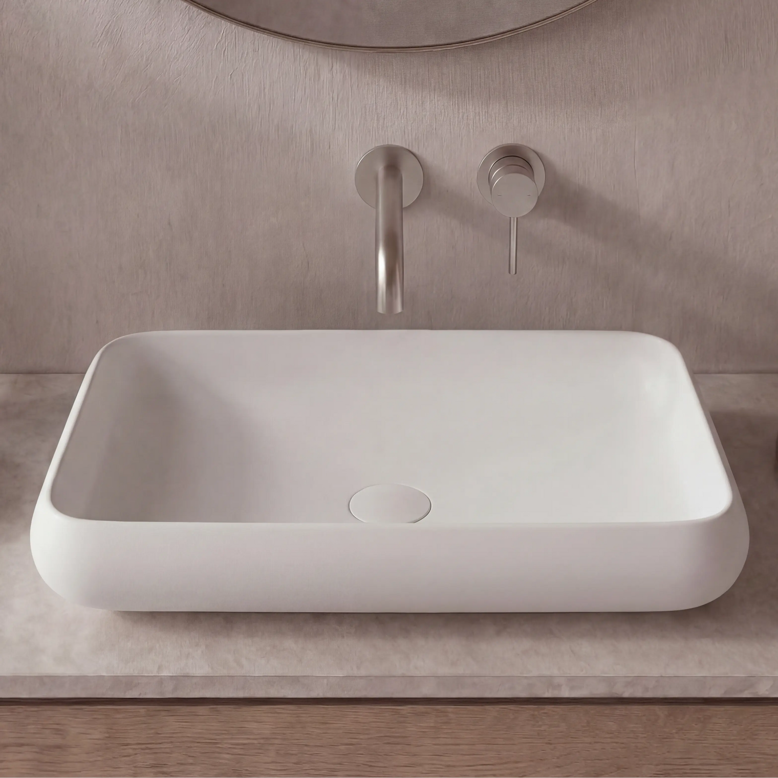 Bathroom sink with faucet and soap dispenser on a neutral-toned wall and countertop.