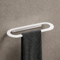 Towel rack with a black towel on a gray wall in a bathroom setting.