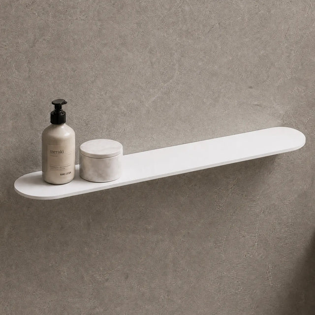 White shelf on a gray wall with bathroom items and a mirror.