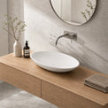 Bathroom vanity with a white sink, wooden cabinet, and decorative items.