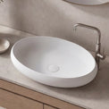 Bathroom vanity with a white sink, wooden cabinet, and decorative elements.