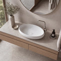 Bathroom vanity with a white sink, wooden cabinet, and decorative elements.