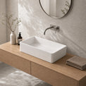 Bathroom vanity with white sink, wooden cabinet, and decorative elements.