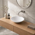 Bathroom vanity with wooden countertop, white sink, and decorative items.