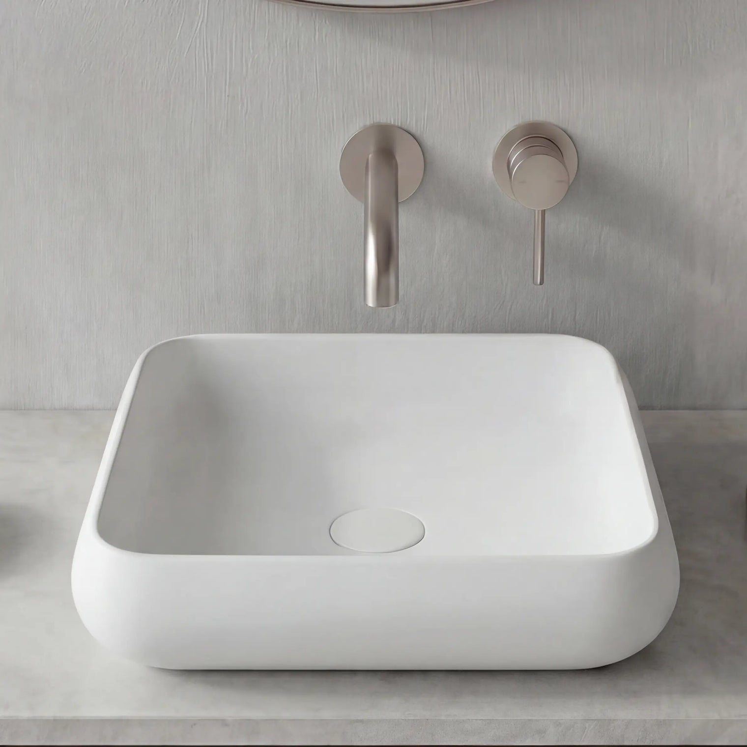 Modern bathroom setup with a white sink, round mirror, and minimal decor.