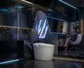 Modern bathroom with a toilet and shower area, featuring a woman sitting on a chair.