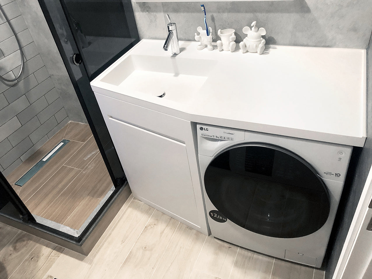 An apartment bathroom installed with INFINITE Bespoke Washbasin and Washing Machine underneath.