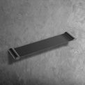bathroom accessory NUUK Shower Shelf 50 in matte black with zinc base and brass pipe mounted on textured wall